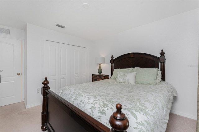 bedroom with a closet, visible vents, light colored carpet, and baseboards