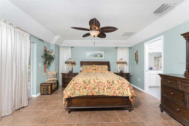 tiled bedroom with visible vents, connected bathroom, a textured ceiling, and baseboards