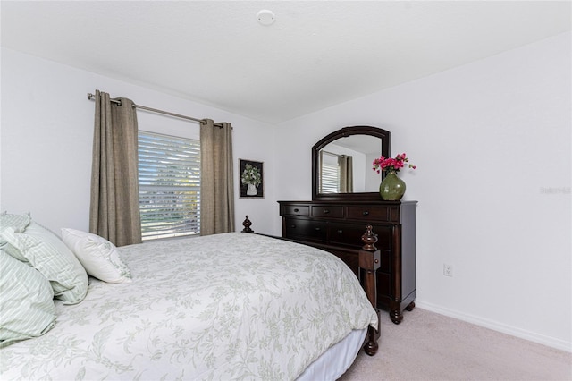 bedroom featuring baseboards and light carpet