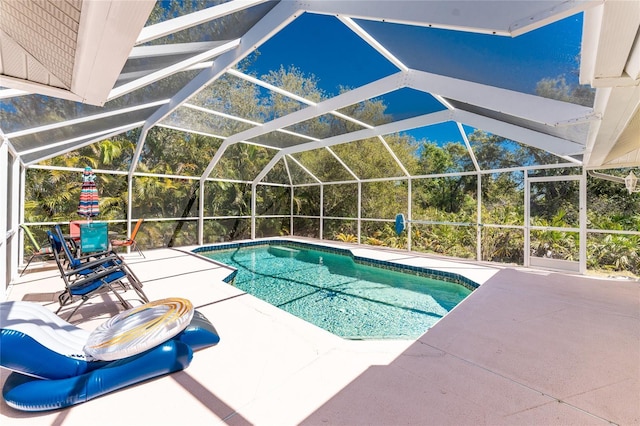 outdoor pool with glass enclosure and a patio