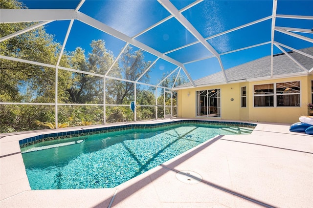 outdoor pool with glass enclosure and a patio