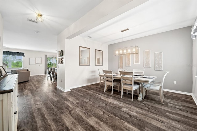 dining room with an inviting chandelier, dark wood-type flooring, visible vents, and baseboards