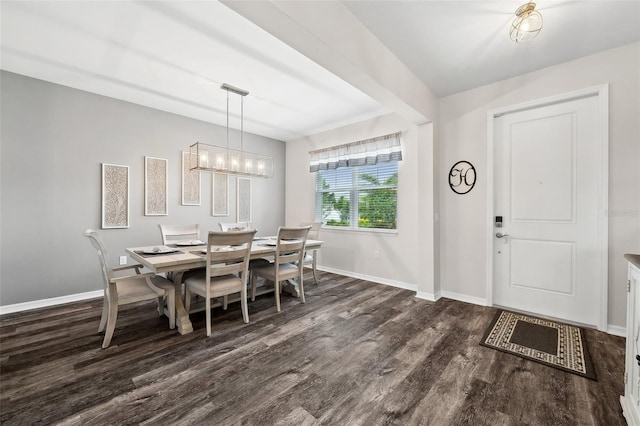 dining area featuring a chandelier, baseboards, and wood finished floors