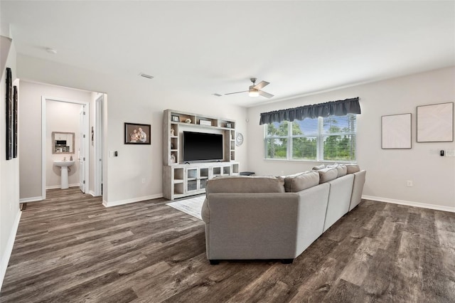 unfurnished living room featuring dark wood finished floors, visible vents, baseboards, and ceiling fan