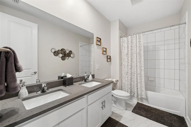 bathroom with double vanity, marble finish floor, toilet, and a sink