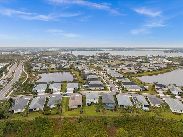 drone / aerial view featuring a residential view and a water view