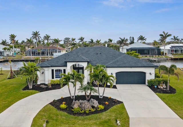 view of front of home featuring driveway, an attached garage, a front yard, and a water view