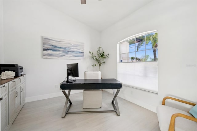 office space with light wood-style flooring, a ceiling fan, and baseboards