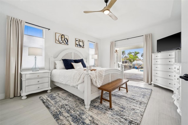 bedroom featuring access to outside, light wood-style floors, and ceiling fan