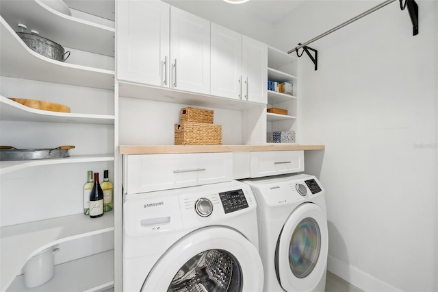 clothes washing area with cabinet space and independent washer and dryer