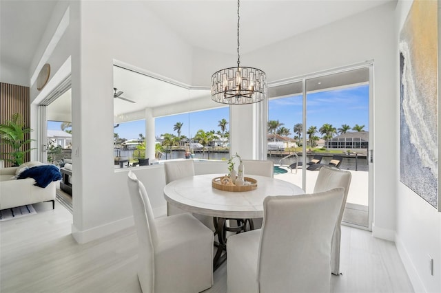 dining room with light wood-style floors, baseboards, and a chandelier