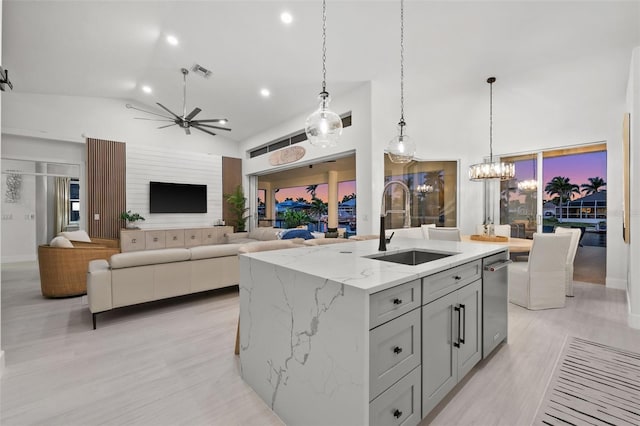 kitchen featuring a sink, light stone counters, and high vaulted ceiling