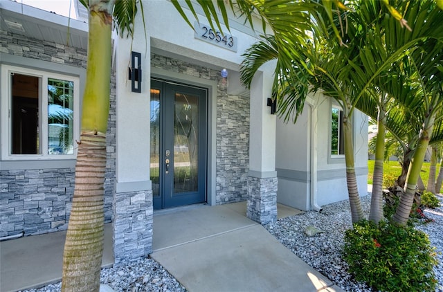 doorway to property featuring stone siding and stucco siding