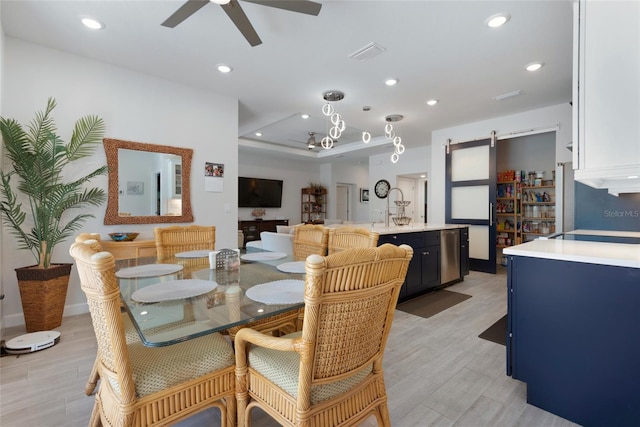 dining room featuring a ceiling fan, visible vents, light wood finished floors, recessed lighting, and a barn door