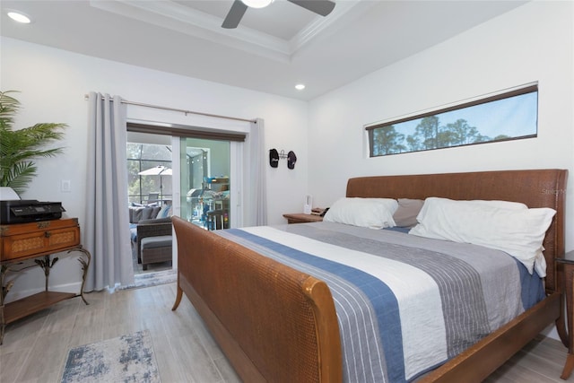 bedroom with light wood finished floors, a tray ceiling, ornamental molding, recessed lighting, and access to outside