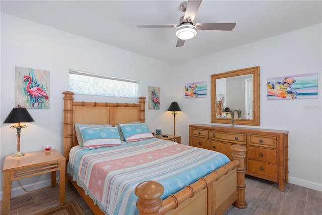 bedroom featuring a ceiling fan, baseboards, and wood finished floors