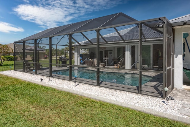 pool with a patio area, a lanai, and a yard