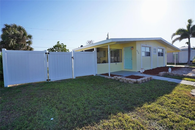 manufactured / mobile home featuring a gate, a front lawn, and fence