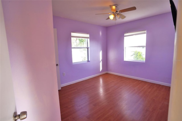 empty room with a ceiling fan, baseboards, and wood finished floors