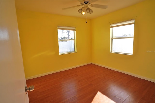 unfurnished room featuring ceiling fan, baseboards, and wood finished floors