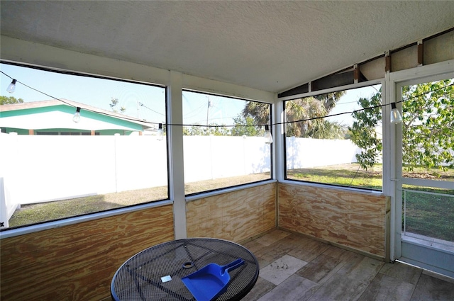 unfurnished sunroom featuring plenty of natural light and vaulted ceiling