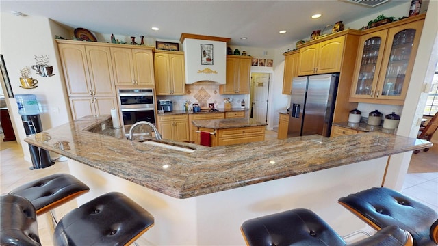 569 Royal Poinciana, Punta Gorda, FL 33955 - kitchen with a kitchen bar, light tile patterned floors, a large island with sink, stainless steel appliances, and a sink