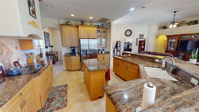 569 Royal Poinciana, Punta Gorda, FL 33955 - kitchen with an island with sink, a sink, backsplash, arched walkways, and stainless steel fridge with ice dispenser