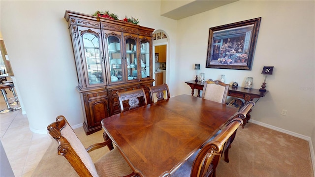 569 Royal Poinciana, Punta Gorda, FL 33955 - dining area featuring light tile patterned floors, baseboards, arched walkways, and light carpet