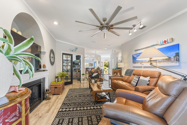 living area featuring ornamental molding, recessed lighting, a fireplace, wood finished floors, and a ceiling fan