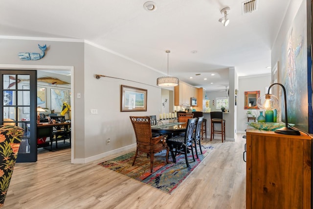 dining room featuring visible vents, baseboards, and light wood-style flooring