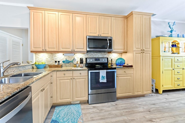 kitchen featuring light brown cabinetry, light wood finished floors, appliances with stainless steel finishes, and a sink