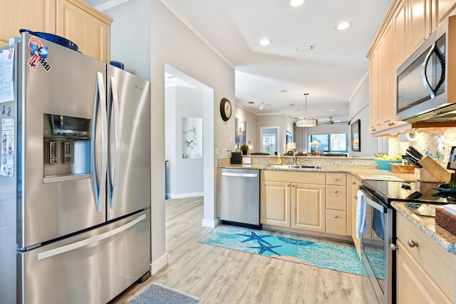 kitchen with light wood-type flooring, stainless steel appliances, light stone counters, and light brown cabinets