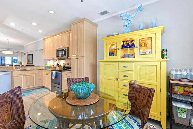 kitchen with visible vents, light brown cabinets, stainless steel appliances, and a sink