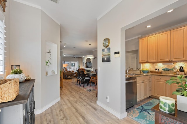 kitchen featuring baseboards, a sink, stainless steel dishwasher, tasteful backsplash, and light wood-type flooring