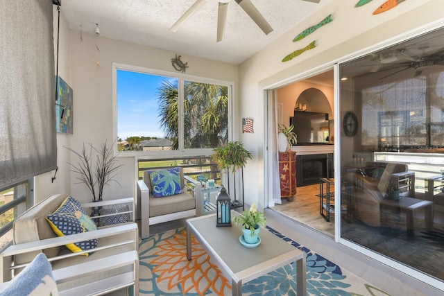 sunroom / solarium featuring a fireplace and ceiling fan