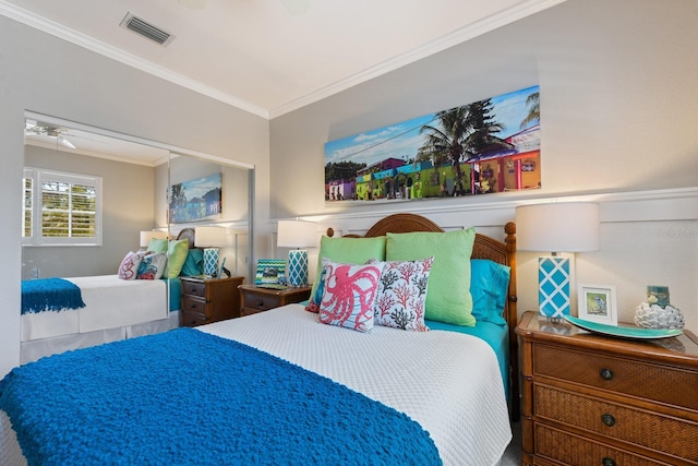 bedroom with ceiling fan, visible vents, a closet, and ornamental molding