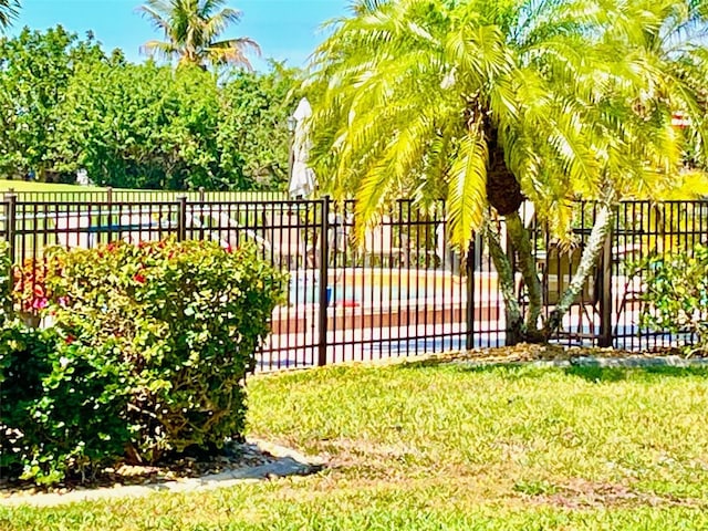 view of gate with a lawn and fence