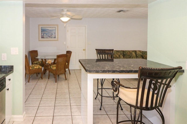 dining room with light tile patterned floors, visible vents, and a ceiling fan