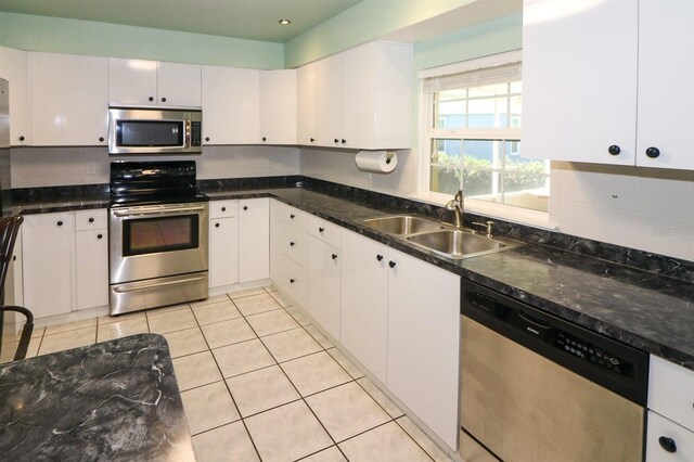 kitchen featuring light tile patterned floors, recessed lighting, appliances with stainless steel finishes, white cabinets, and a sink