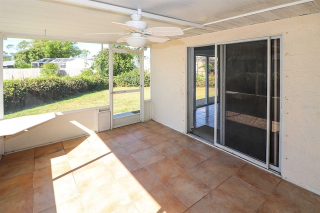 unfurnished sunroom with ceiling fan