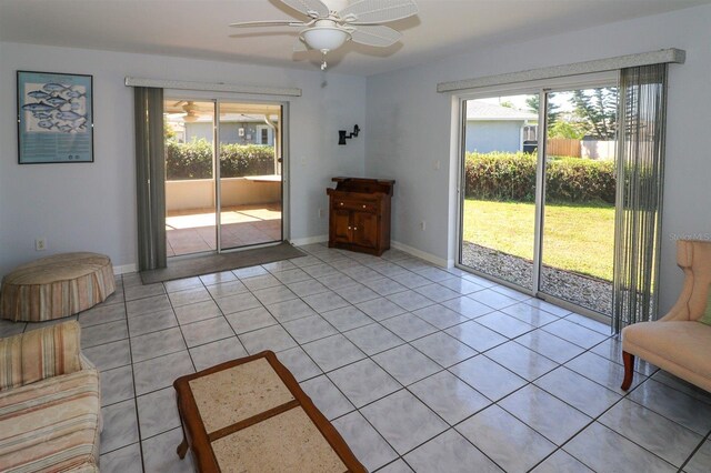 interior space featuring light tile patterned floors, a healthy amount of sunlight, baseboards, and a ceiling fan