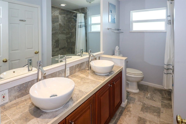 full bathroom featuring a shower with curtain, baseboards, and a sink