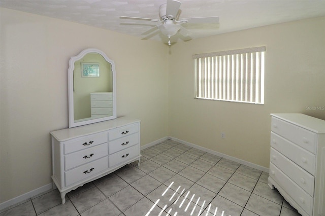 bedroom featuring light tile patterned flooring, a ceiling fan, and baseboards