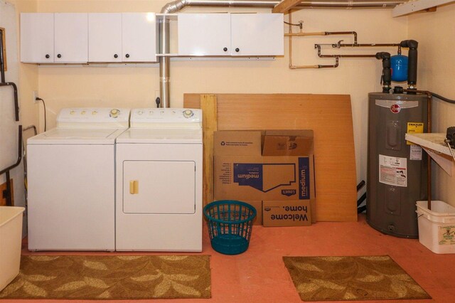 clothes washing area featuring cabinet space, washing machine and dryer, and electric water heater