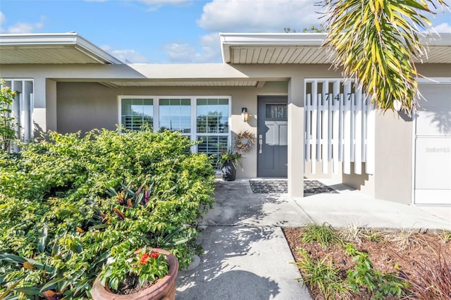 entrance to property featuring stucco siding