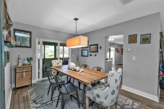 dining space with visible vents, a textured ceiling, baseboards, and dark wood-style flooring