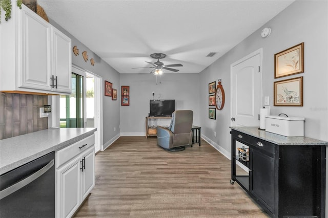 kitchen with visible vents, ceiling fan, light countertops, white cabinets, and stainless steel dishwasher