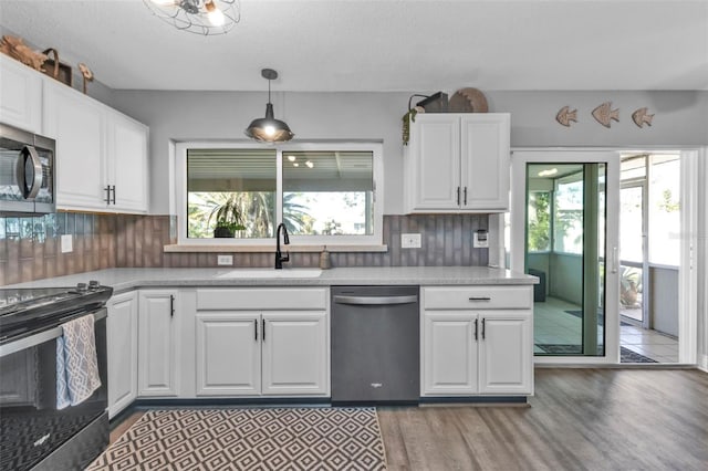 kitchen with a healthy amount of sunlight, white cabinetry, stainless steel appliances, and a sink