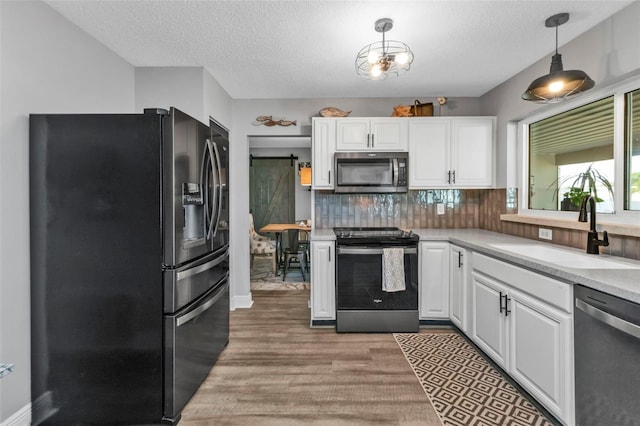 kitchen featuring a sink, stainless steel appliances, white cabinetry, and light countertops