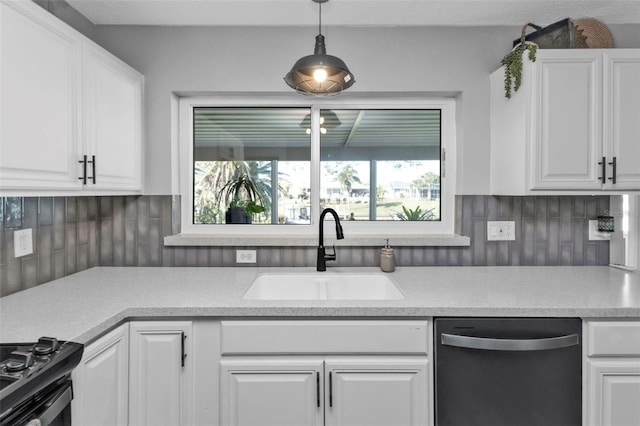 kitchen featuring a sink, dishwashing machine, white cabinetry, and gas stove